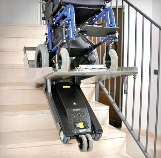 dettaglio di funzionamento di Jolly su una rampa di scale. La pedana mantiene la sedia a rotelle parallela al terreno, mentre il prodotto scorre lungo le scale