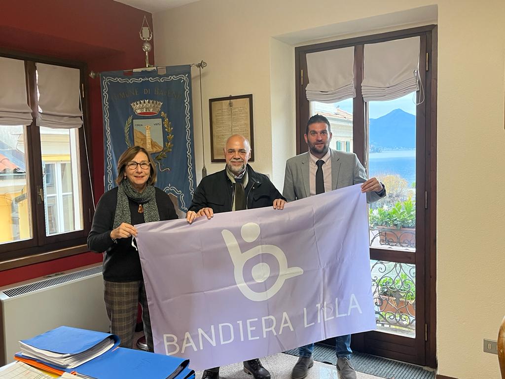 Il presidente di Bandiera Lilla con il sindaco e assessore di Baveno mostra la Bandiera Lilla