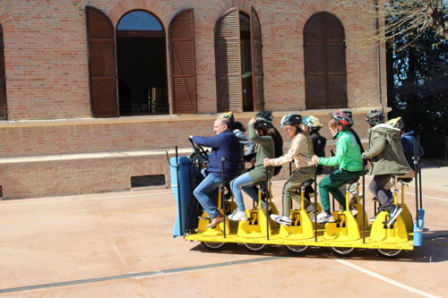 un gruppo di persone a bordo della versione scoperta di cyclebus