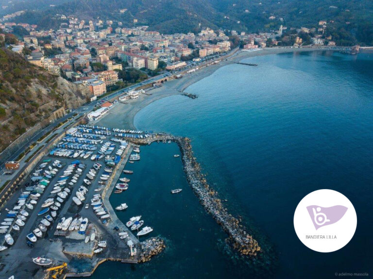 Una vista aerea di Levanto, con in sovraimpressione la bandiera lilla