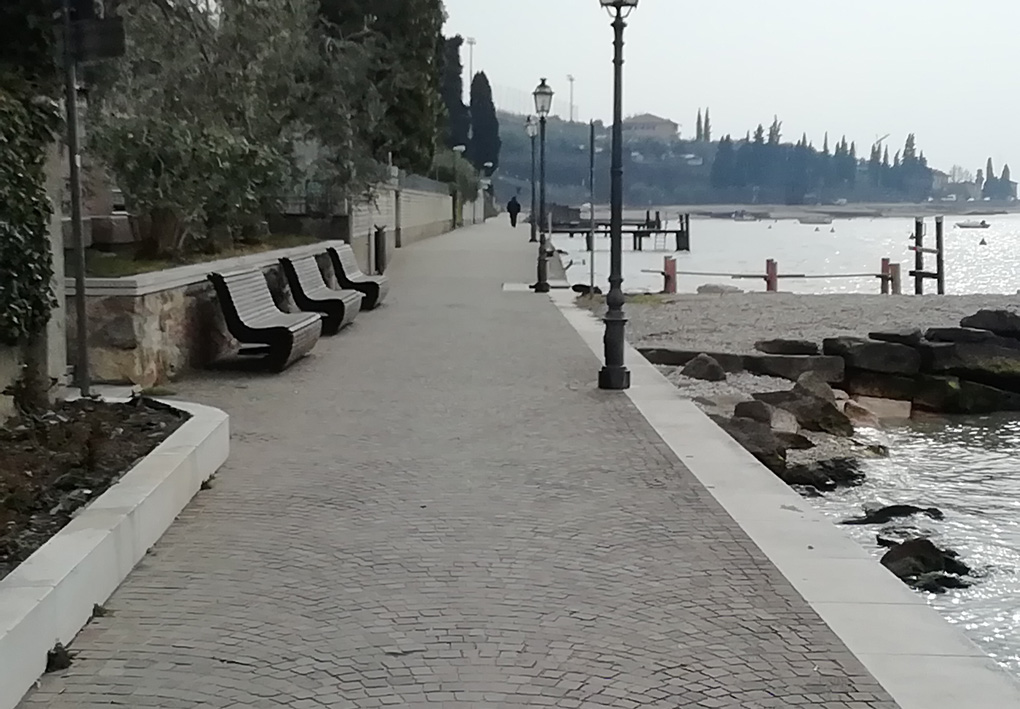 Una passeggiata lungomare con panchine e aiuole