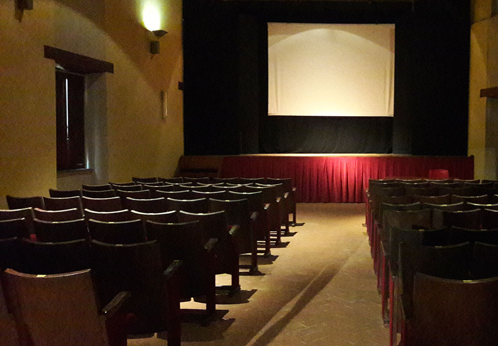 la platea di un teatro con un corridoio centrale tra le due file