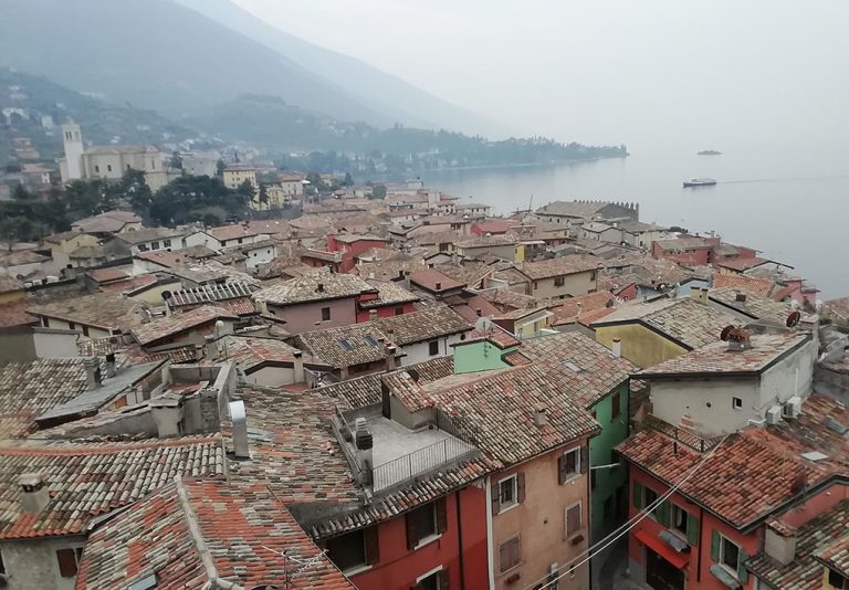 panorama sui tetti della città. Sullo sfondo il lago e le colline.