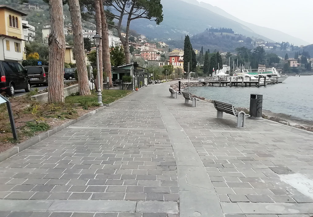 passeggiata lungolago con panchine. Aiuole con alberi separano l'ampia zona pedonale dalla strada