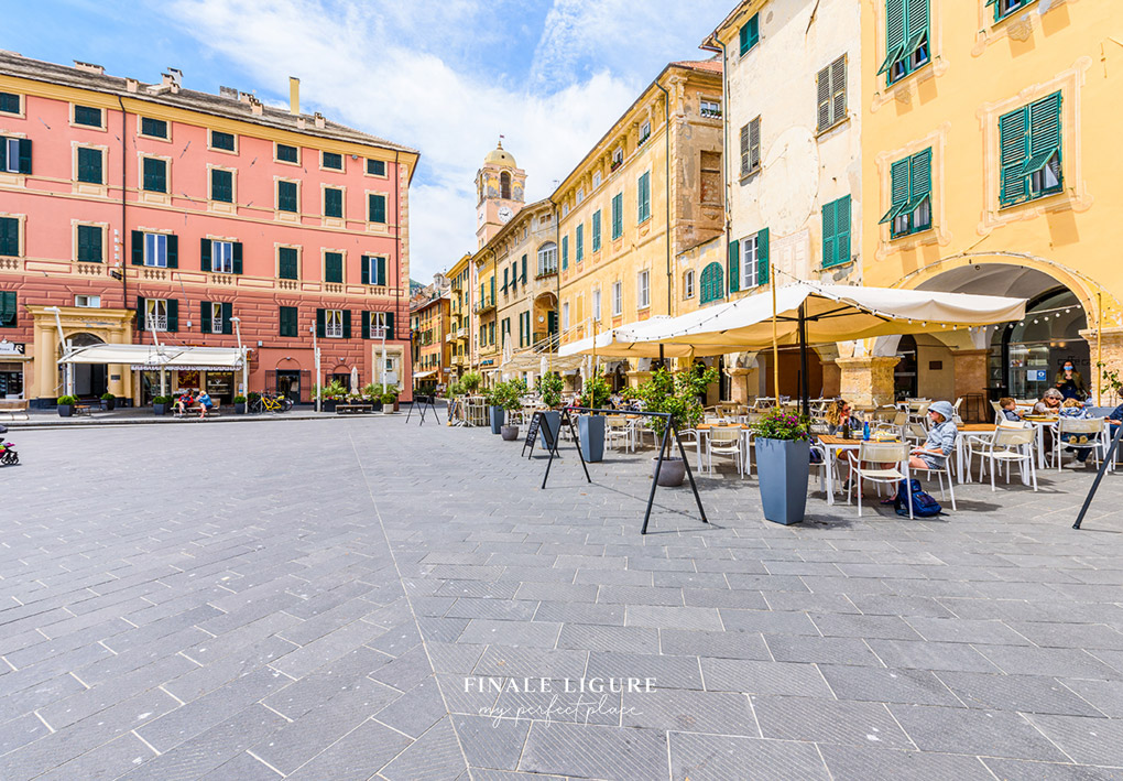 una piazza con ombrelloni e locali