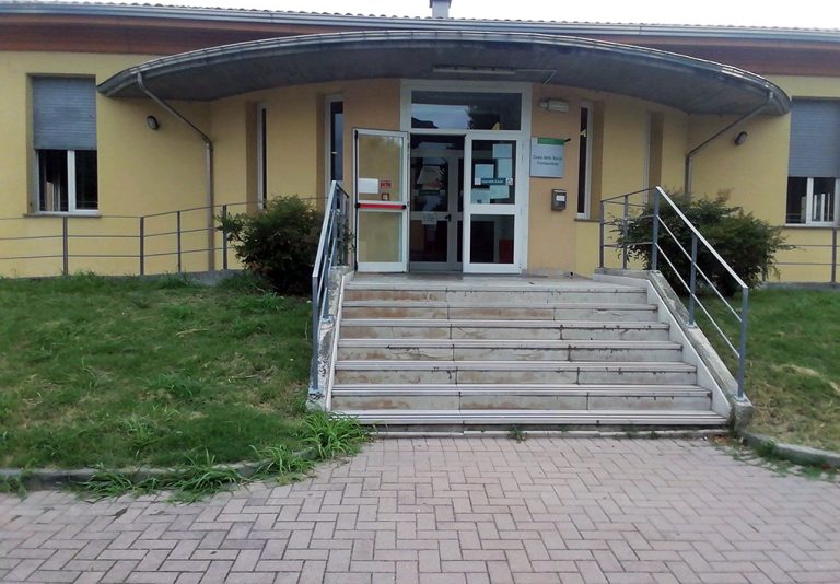 Un edificio basso, moderno. ai lati della scalinata, un'aiuola d'erba copre il raccordo con la rampa laterale di accesso