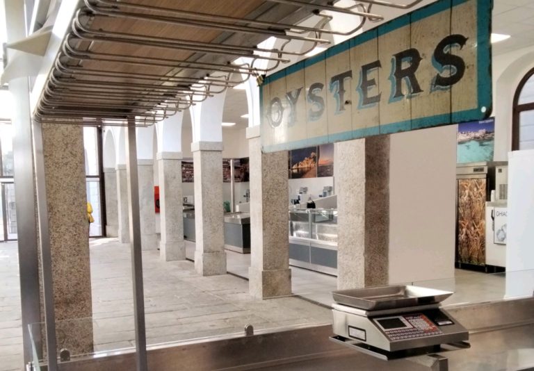 In una struttura di recente costruzione, un grande cartello indica uno dei banconi