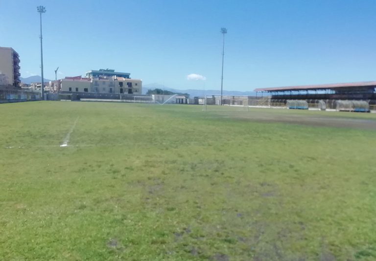 Un campo da calcio in erba con spalti ai lati