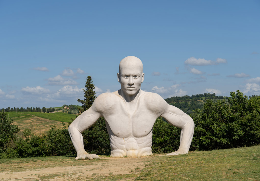 La statua posizionata alle spalle dell'anfiteatro. Un uomo gigantesco si appoggia al terreno come se si stesse issando dalle profondità della terra
