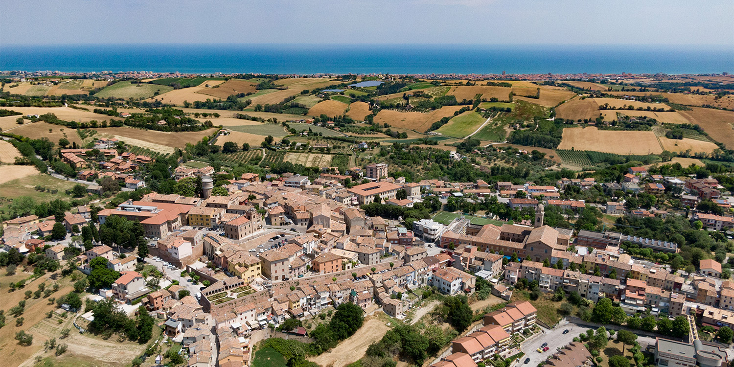vista aerea del borgo, con intorno i campi e sullo sfondo il mare