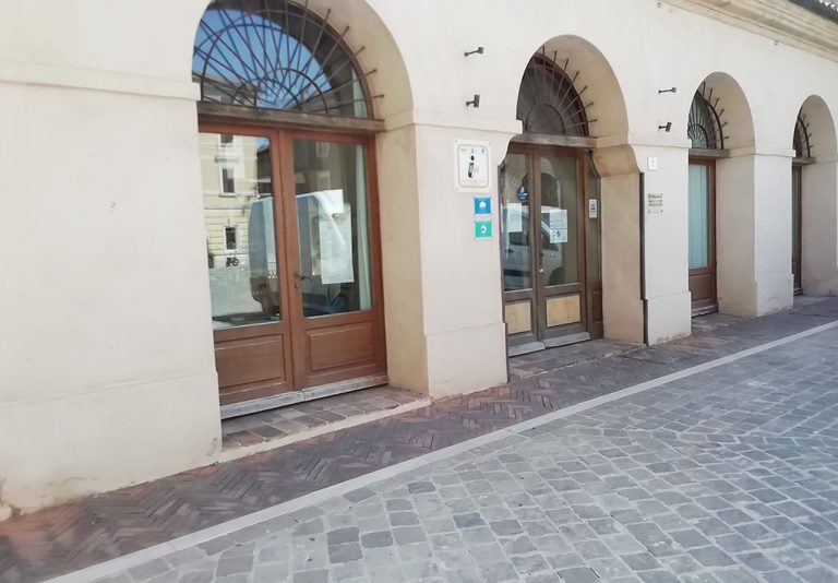 Accesso all'infopoint, con porte ad arco e vetrine che danno sulla strada
