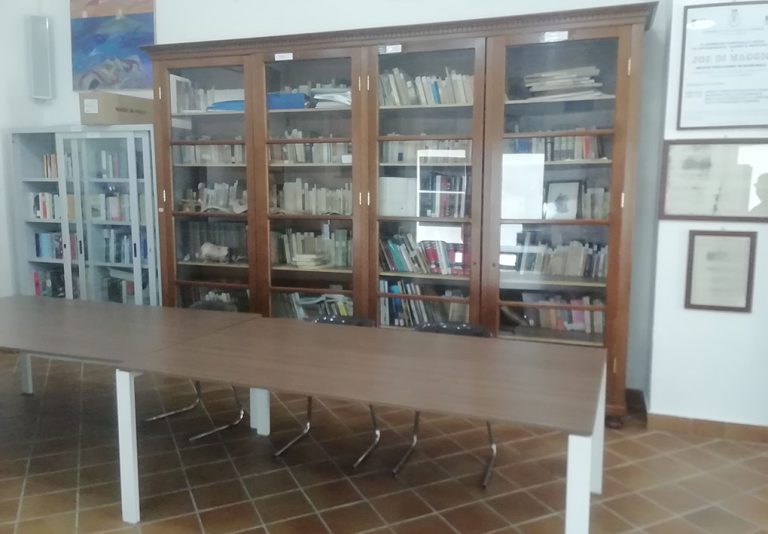scaffali pieni di libri alle spalle di tavoli da consultazione