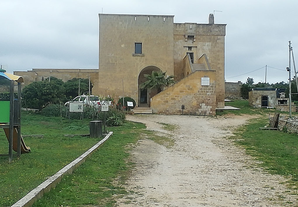 una strada in terra battuta porta a un edificio storico nel parco.