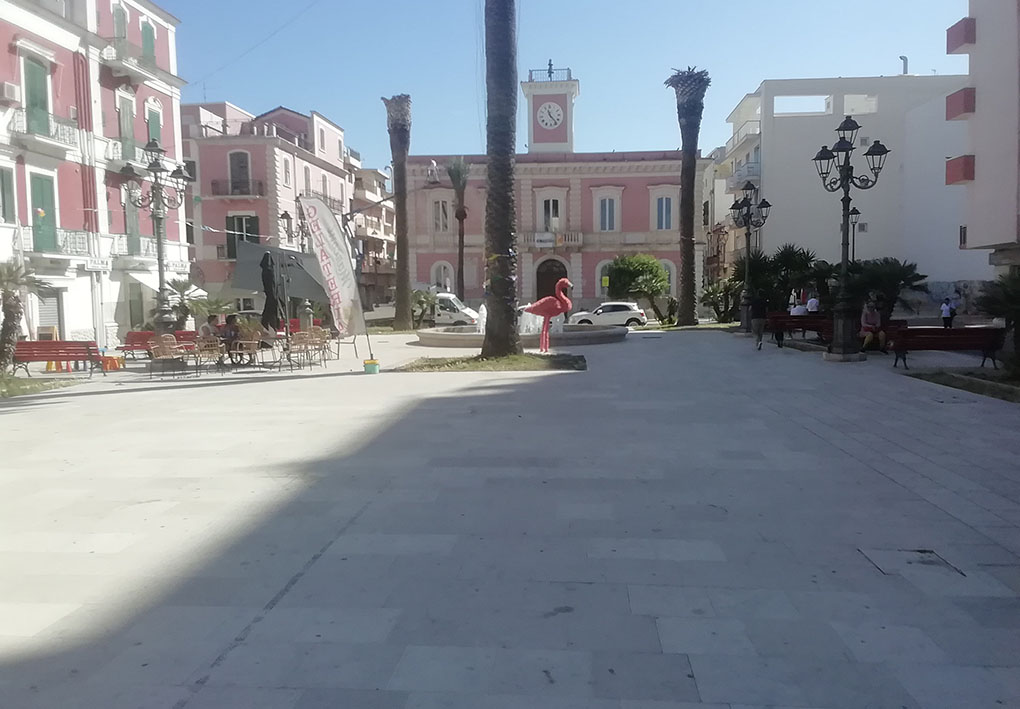 una piazza pedonale con palme e aiuole