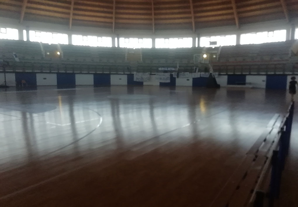 interno di un palazzetto dello sport circolare. Gli spalti rialzati circondano il campo in legno