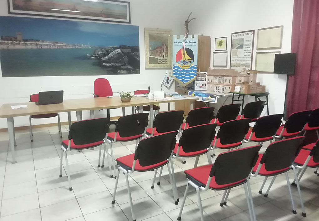 una piccola sala riunioni con un tavolo e sedie a formare una platea