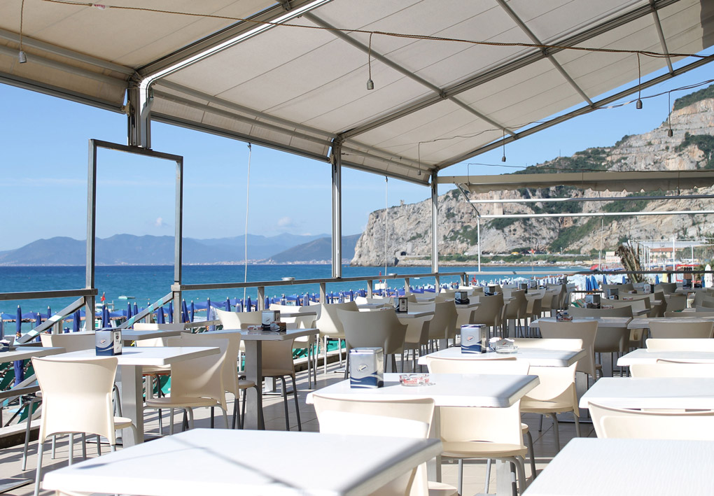 tavoli apparecchiati su una terrazza sul mare