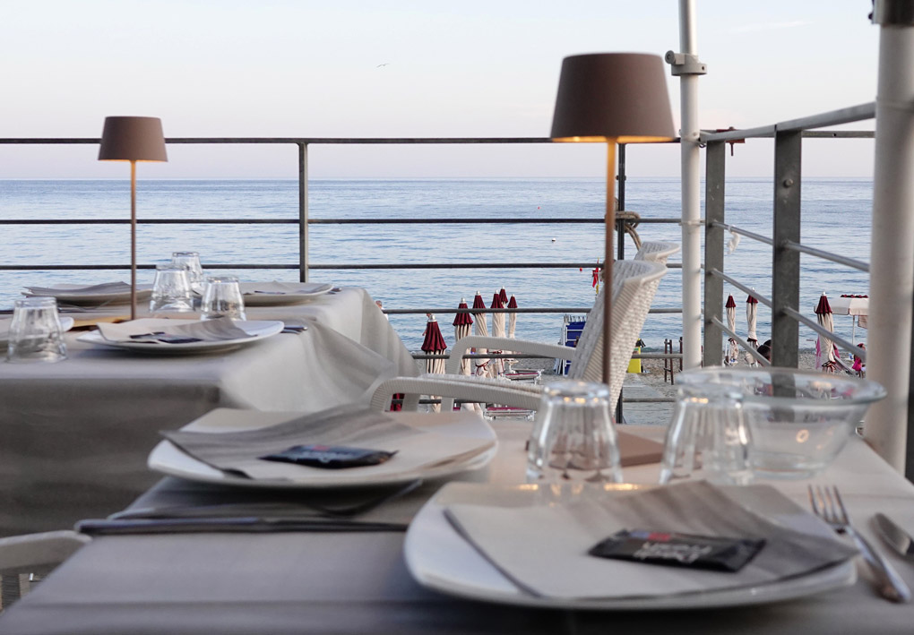 Una tavola apparecchiata su una terrazza in riva al mare