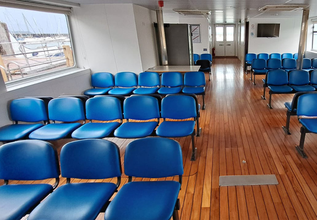 sala interna chiusa, con file di sedie di plastica vicino agli ampi finestrini. A lato un ampio corridoio permette il passaggio. Il pavimento è in legno lucidato, dando all'ambiente una sensazione di calore.