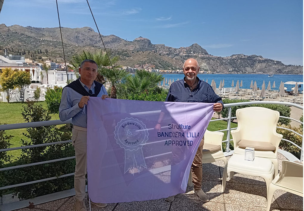 Il presidente di Bandiera Lilla consegna il riconoscimento al gestore dello stabilimento