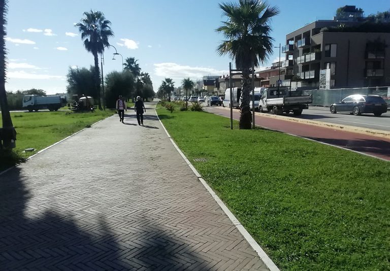 La pista pedonale corre tra il lungomare e le aiuole, parallela alla strada, ma separata da questa attraverso un cordolo rialzato
