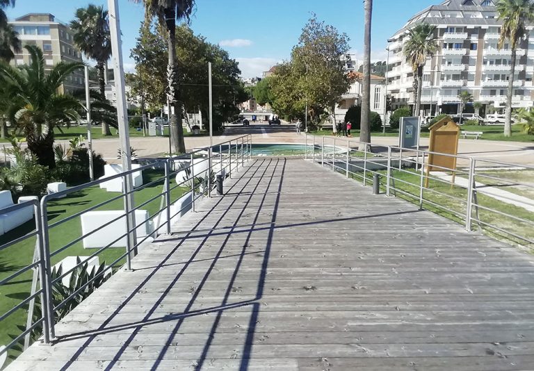 una banchina di legno si allunga da una piazza circolare del lungomare