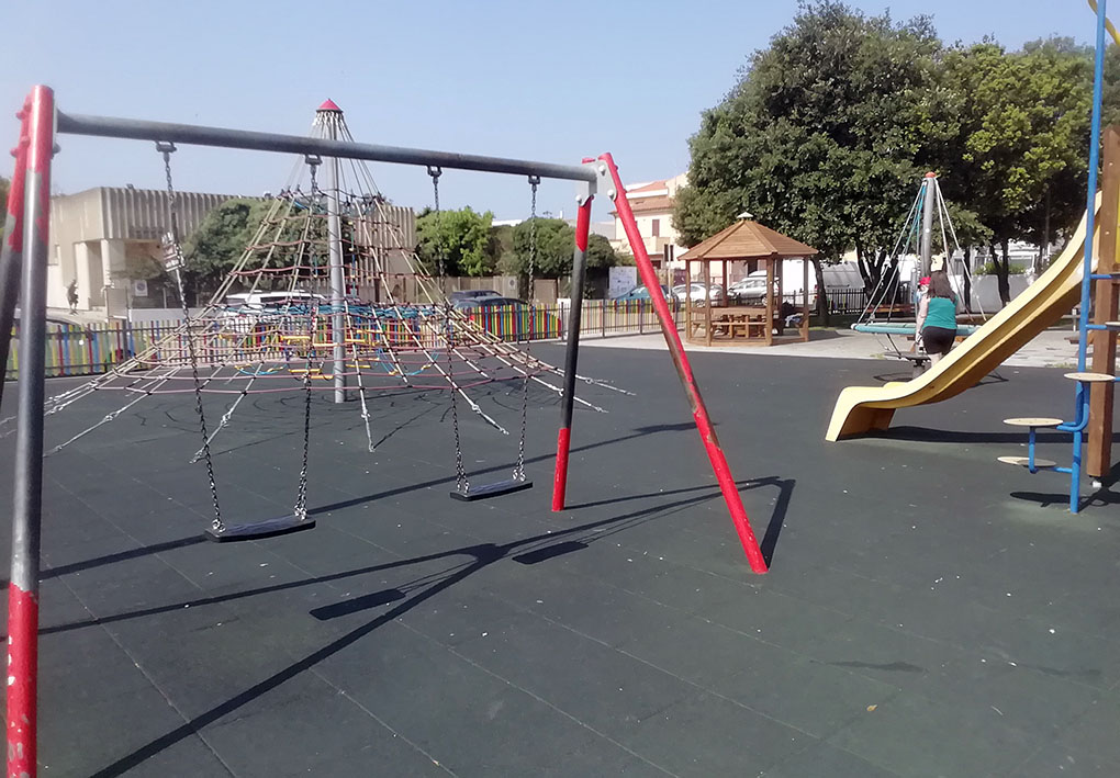 un parco giochi con strutture gioco colorate, circondato da un recinto in legno colorato