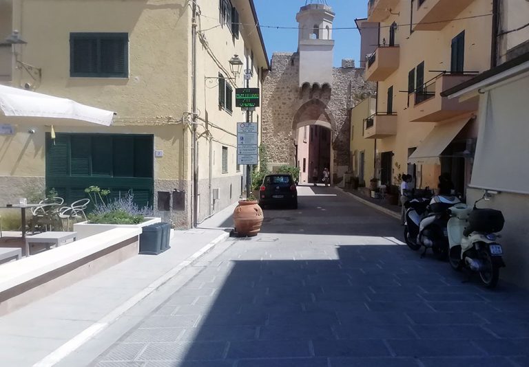 centro storico con pavimentazione rugosa, via stretta circondata da edifici