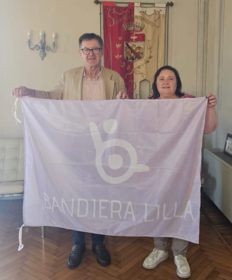 Il Sindaco e l'Assessore di Fontanellato posano con la Bandiera Lilla durante la cerimonia di consegna