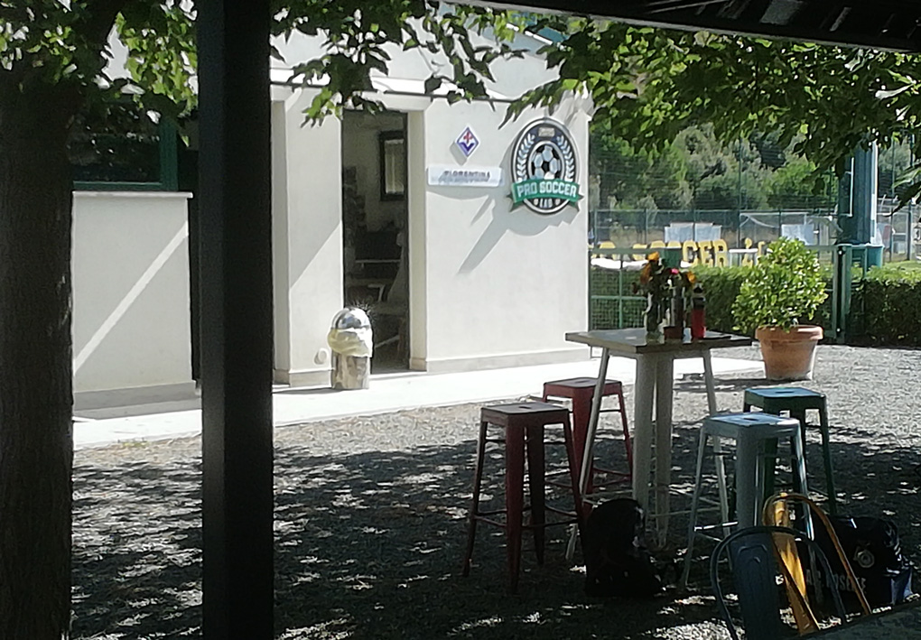 un accogliente punto ristoro con tavolini all'aperto all'ombra di una pergola