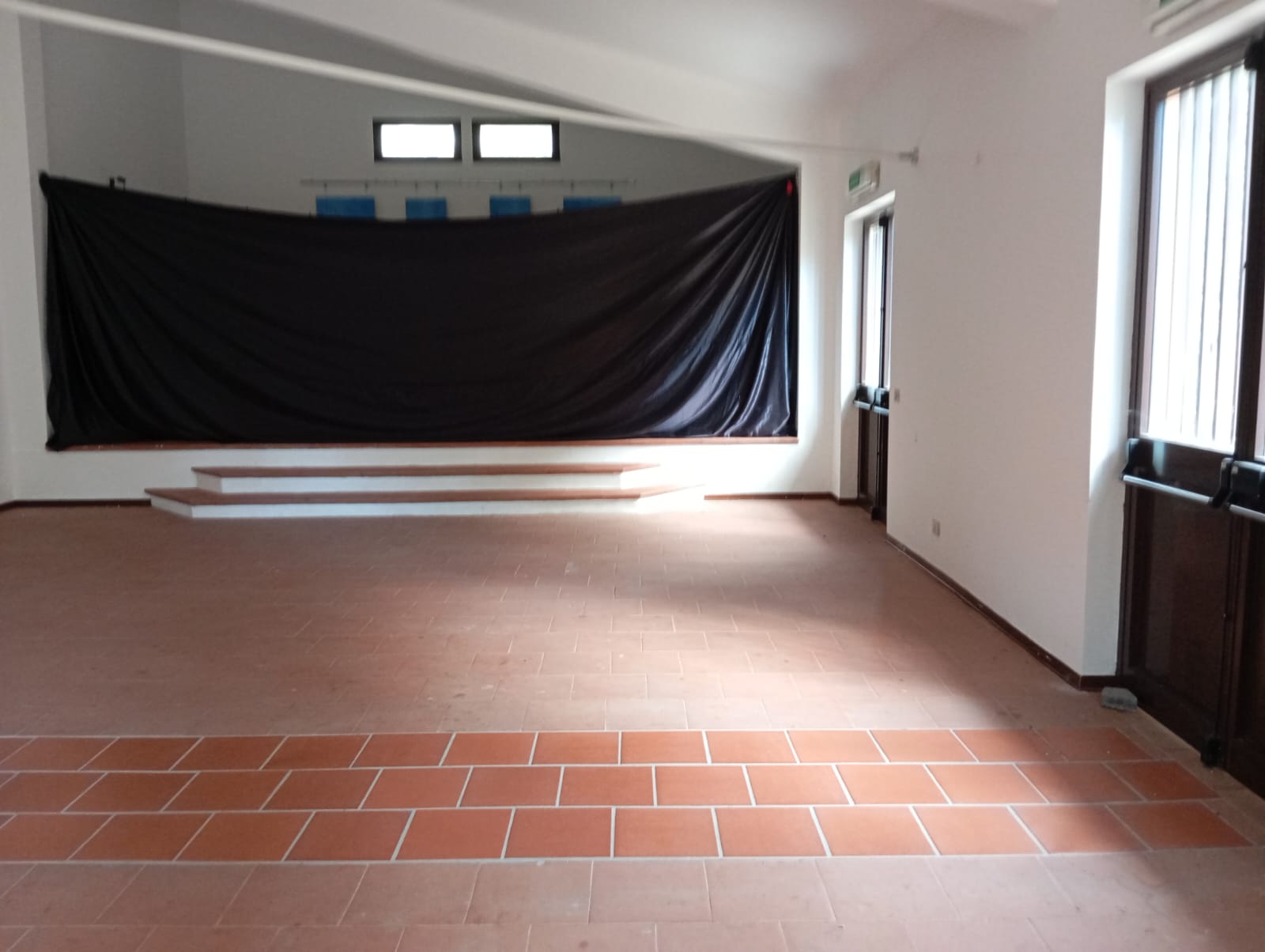 sala interna adibito a spazio teatrale. con palco e una sala.