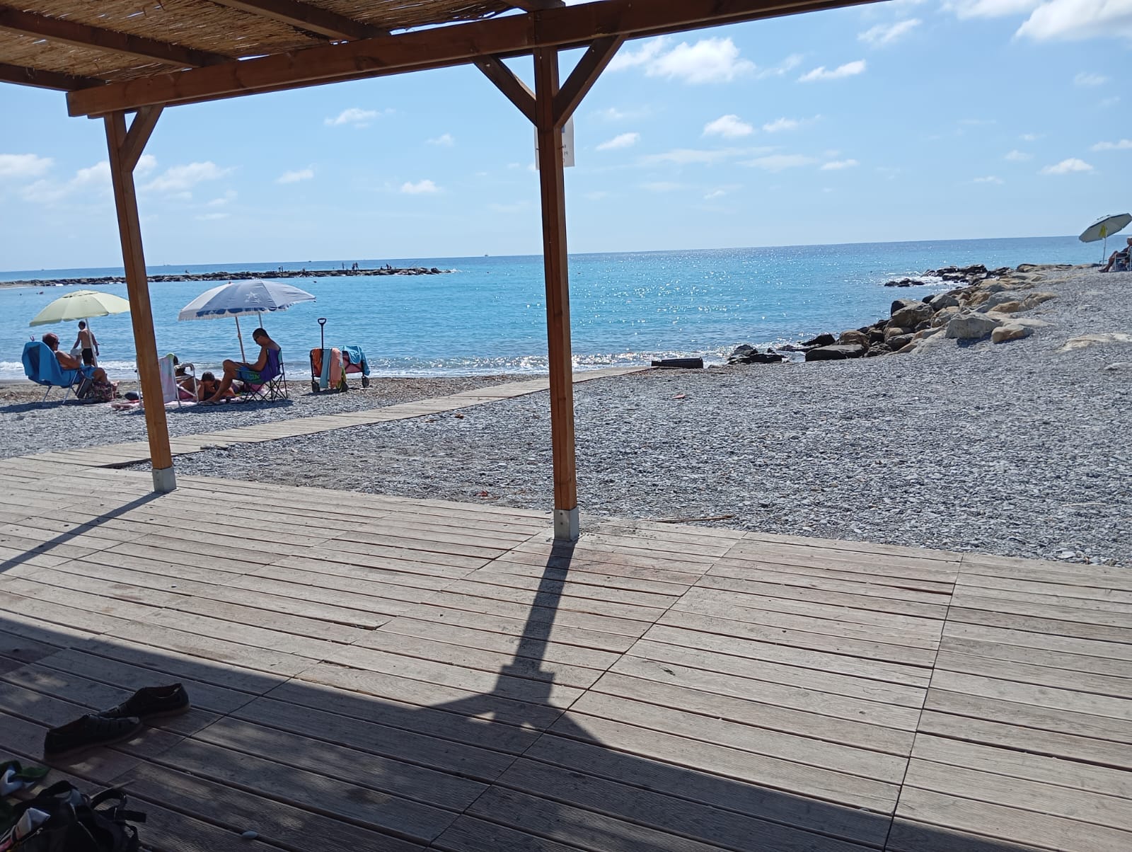 paesaggio di spiaggia con ciottoli e struttura in legno come passerella.