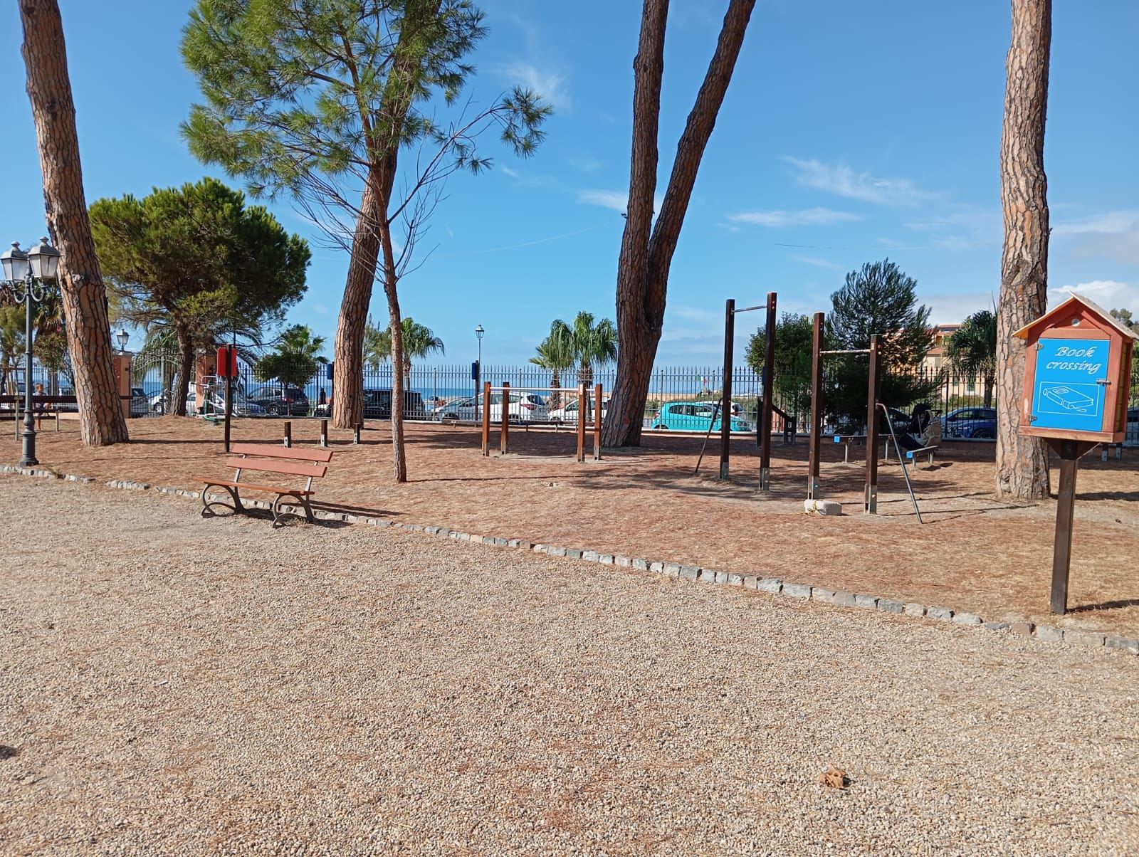 Giaridni pubblici con ghiaia come pavimentazione, alberi nello sfondo insieme ad un cielo sereno e azzurro