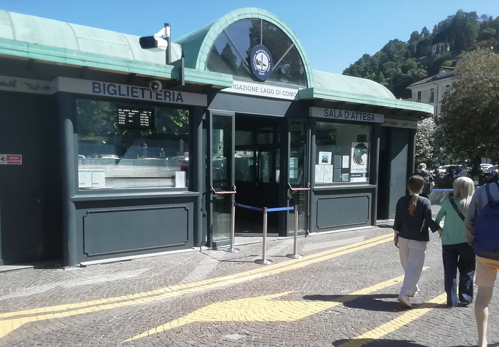 un basso edificio liberty al piano strada con le porte aperte. una piccola transenna fissa protegge la'ccesso pedonale dalla strada