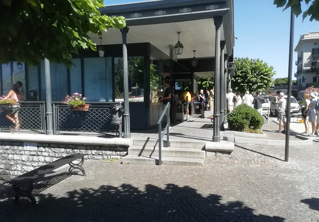 3 scalini da un lato e una rampa dall'altro, consentono l'accesso a una pensilina in stile liberty in una ampia piazza alberata