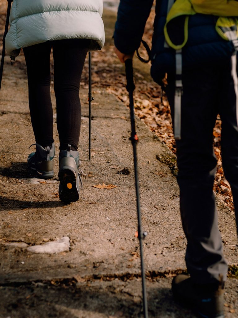 Due persone in escursione inquadrate di schiena dalla vita in giù