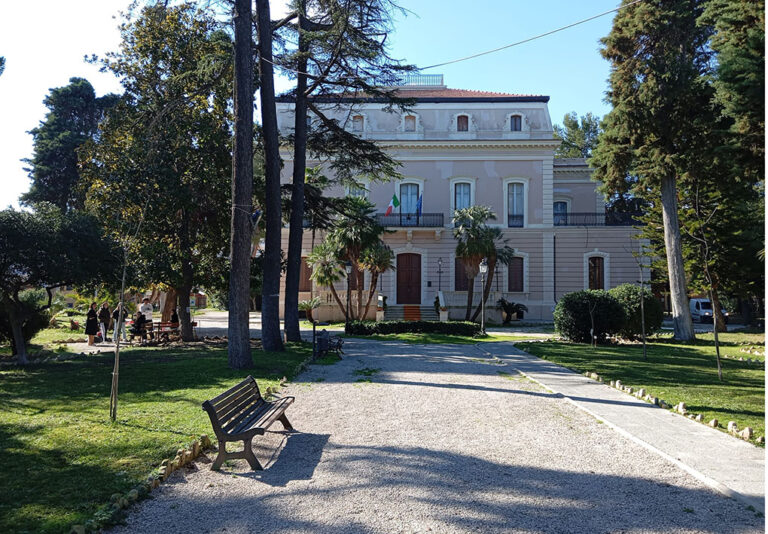Edificio storico con giardino curato e visitatori