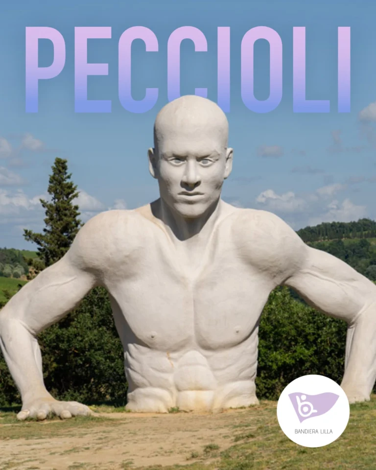Manifesto promozionale con la scritta "PECCIOLI" in alto, colorata con una sfumatura lilla e azzurra. Al centro campeggia la grande scultura bianca di un uomo a mezzo busto che emerge dal terreno, situata in un prato all'aperto con colline e alberi sullo sfondo. In basso a destra è presente il logo di Bandiera Lilla.