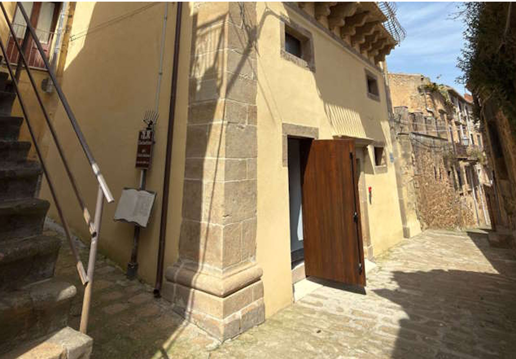 un antico palazzo si affaccia su una via ordinata, lastricata in pietra. Il grosso portone in legno è aperto per accogliere gli ospiti
