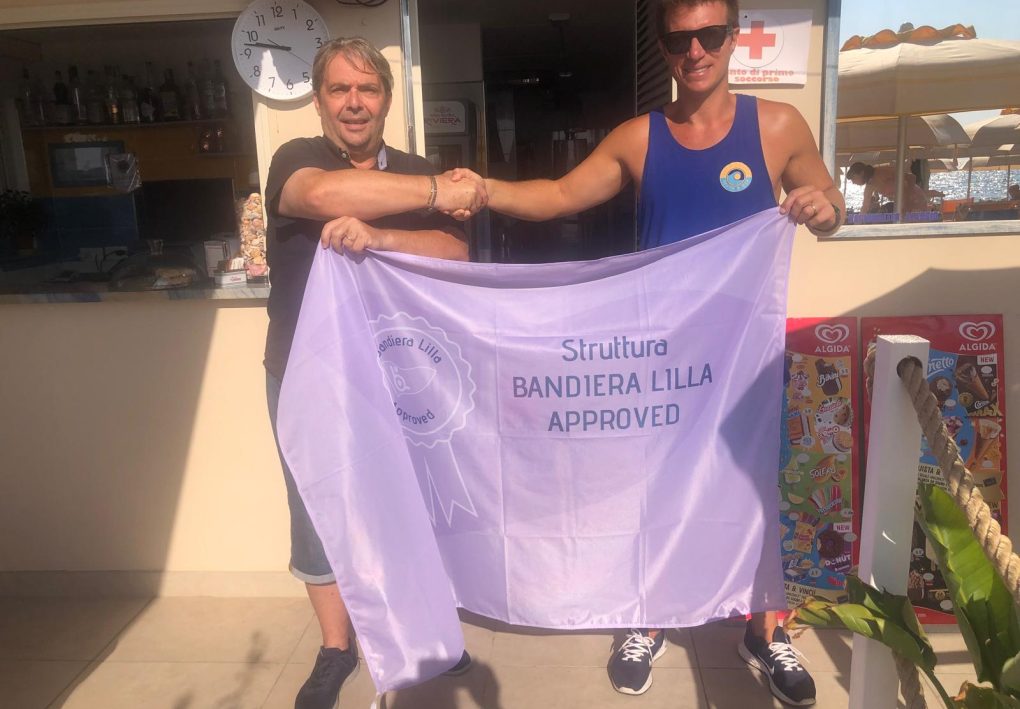 il responsabile del settore aziende di Bandiera Lilla Paolo Rogna posa con il gestore dei Bagni Walter durante la consegna del riconoscimento